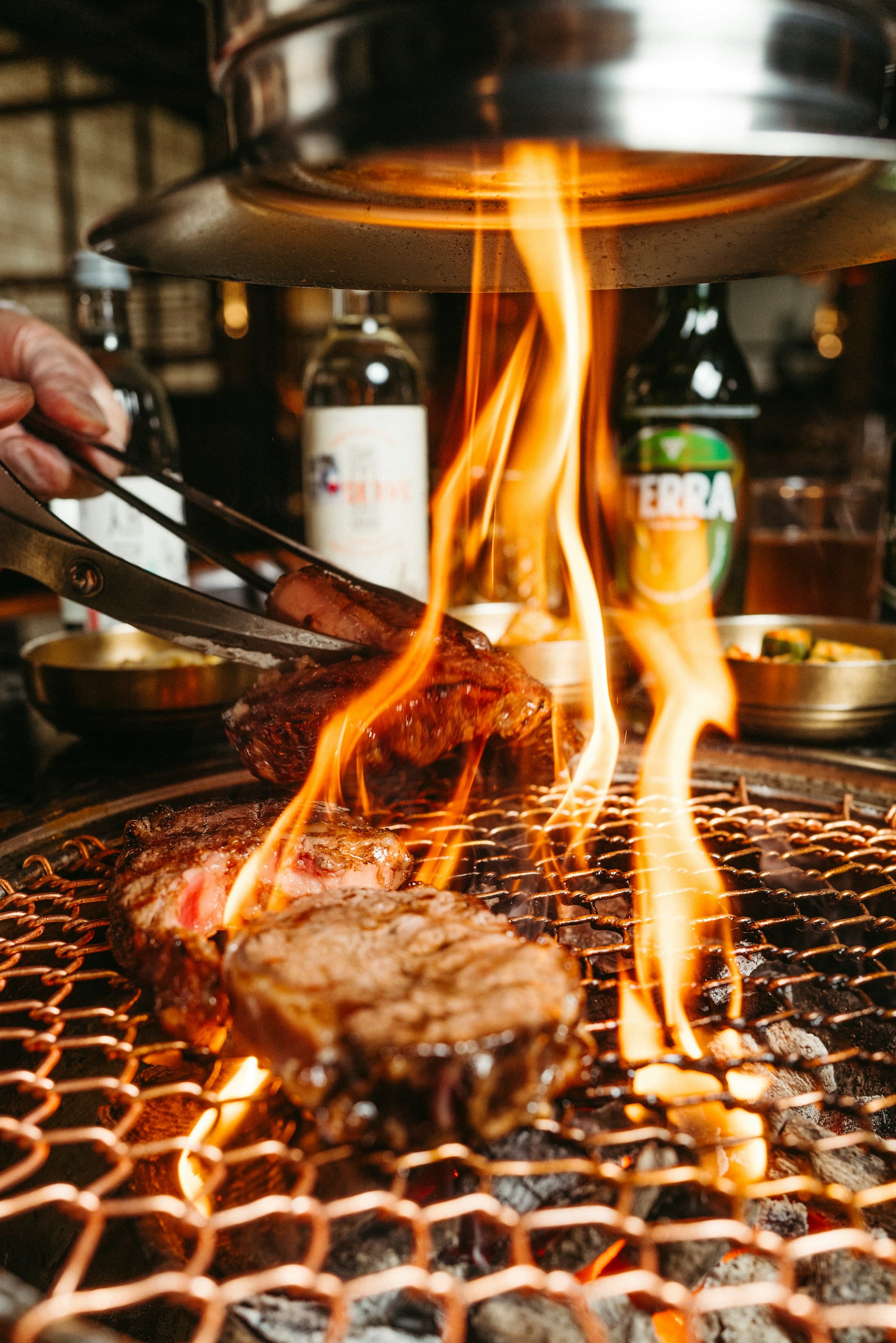 Korean barbecue cooking over an open grill flame